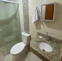 Chuveiro, toalhas de banho, sabonete, shampoo