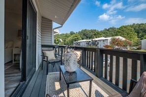A balcony with a table, chair, and decorative lantern. - Luxury in the Heart of Homewood! (Birmingham)