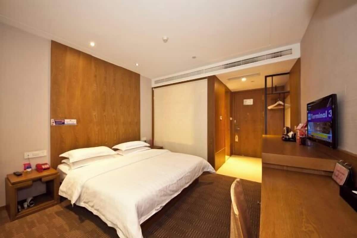 Une chambre d’hôtel équipée d’un lit, d’une télévision, d’un bureau et d’une armoire.