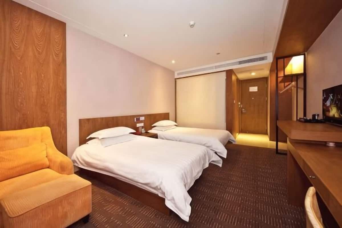 Une chambre d’hôtel avec deux lits, un canapé, un bureau et une télévision.