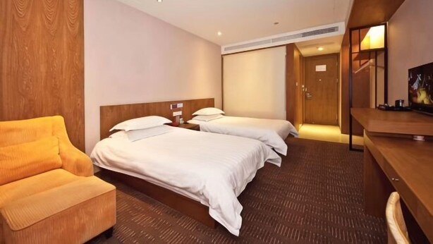 Une chambre d’hôtel avec deux lits, un canapé, un bureau et une télévision.