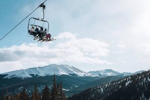 A ski lift with skiers ascending a mountain. - Premier 2 Bedroom Townhome Across From Snowflake Lift - Walk to Lifts (Breckenridge)