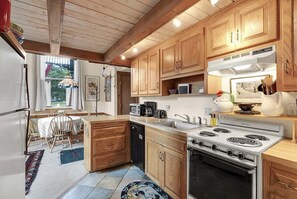Una cocina con armarios de madera, estufa, microondas y lavavajillas.