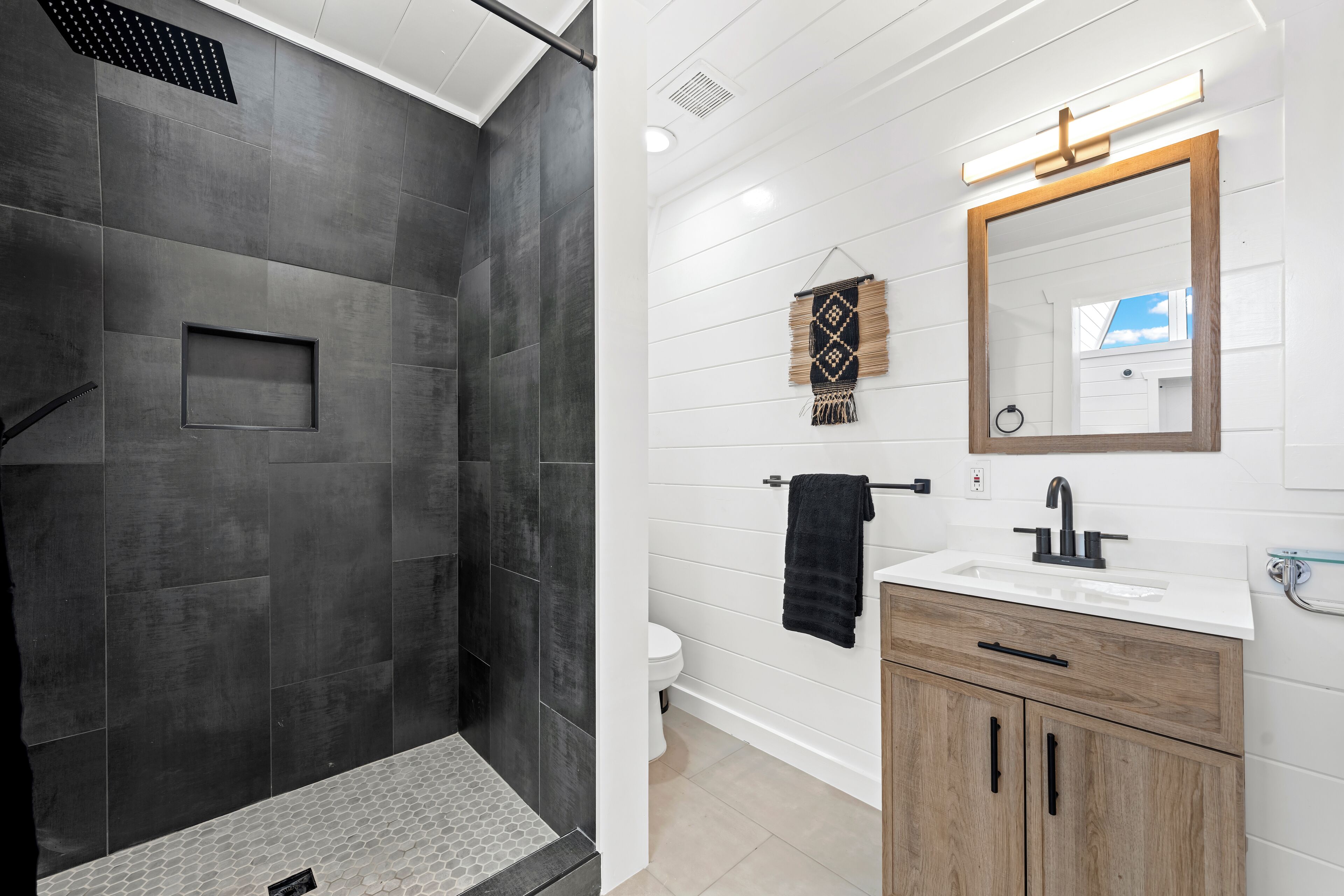 A modern bathroom with a shower, toilet, and vanity.