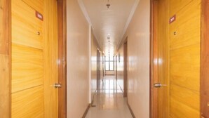 Ein Hotelgang mit Holztüren, jede Tür mit einer Zimmernummer gekennzeichnet.