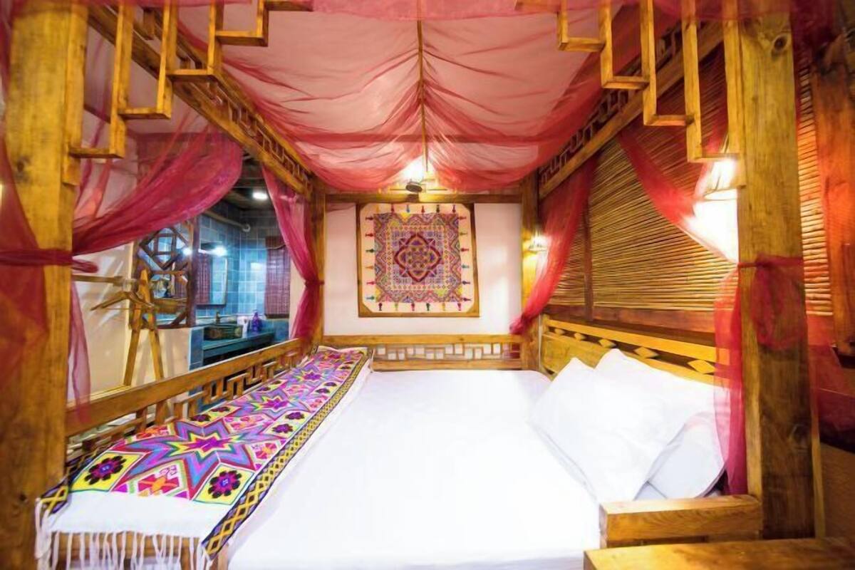 Quarto com cama, mobiliário de madeira e um objeto decorativo na parede.