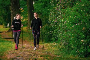 Two people walking on a path in a wooded area. - Apartmánový Komplex Dagmar (Jachymov)