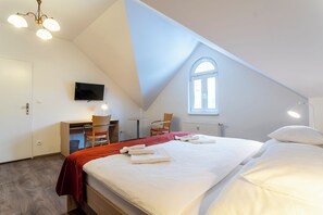 A bedroom with a large bed, a desk, a chair, a TV, and a window. - Apartmánový Komplex Dagmar (Jachymov)