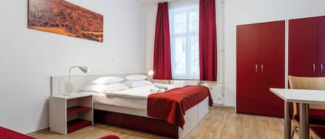 Un dormitorio moderno con cama, mesita de noche y un armario rojo.