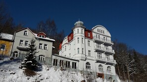 Un edificio grande de varios pisos con un estilo arquitectónico clásico, que destaca por una cúpula prominente y varios balcones.