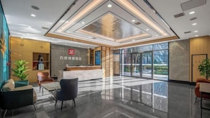 A modern hotel lobby with a reception desk, seating area, and large windows offering a view of the outdoors. - Wanbang Zundi Hotel (Xi'an High-tech Wanda Plaza Mutasi Subway Station Branch) (Xi'an)