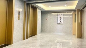 A modern hotel lobby with marble flooring, gold accents, and a framed artwork on the wall. - Wanbang Zundi Hotel (Xi'an High-tech Wanda Plaza Mutasi Subway Station Branch) (Xi'an)