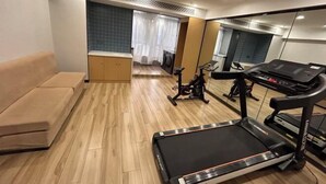 A modern living room with a treadmill, exercise bike, and a sofa. - Wanbang Zundi Hotel (Xi'an High-tech Wanda Plaza Mutasi Subway Station Branch) (Xi'an)