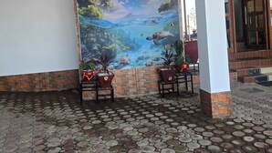 Un mural grande que muestra una escena submarina tropical con plantas en macetas al frente.