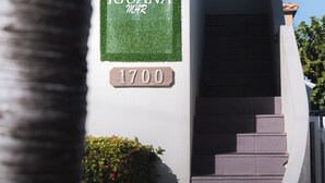 Rakennuksen sisäänkäynti, jossa on kyltti, jossa lukee ”IGUANA HOTEL”, ja sen alla numero ”1700”.