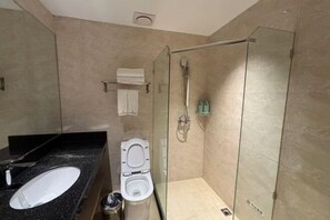 A modern bathroom with a glass-enclosed shower, a white toilet, and a black countertop with a sink. - Xiangtan Jinguiyuan Hotel (Government City Wanda Plaza) (Xiangtan)