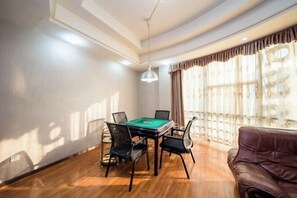 A room with a pool table, four chairs, a brown leather sofa, and large windows with curtains. - Xiangtan Jinguiyuan Hotel (Government City Wanda Plaza) (Xiangtan)