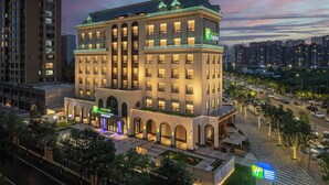 A multi-story Holiday Inn Express building with a central courtyard, surrounded by high-rise residential buildings.