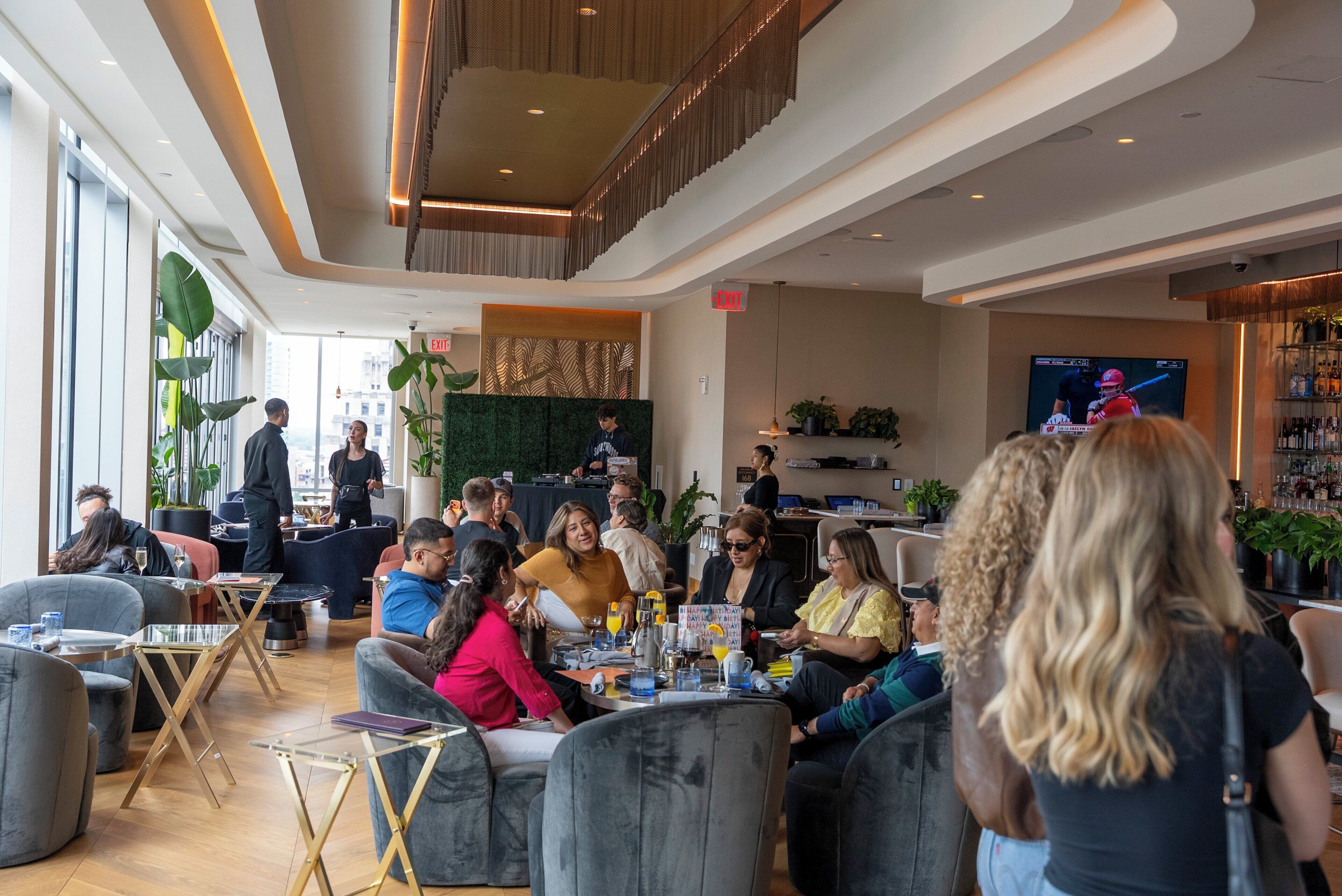 Un espace intérieur moderne, aménagé avec des coins salon, un téléviseur et un bar.