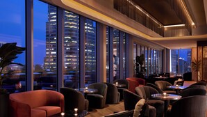 A modern lounge area with comfortable seating, large windows offering city views, and ambient lighting. - InterContinental Indianapolis by IHG (Indianapolis)