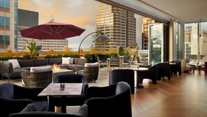 A rooftop lounge with outdoor seating, a fire feature, and a view of the cityscape. - InterContinental Indianapolis by IHG (Indianapolis)