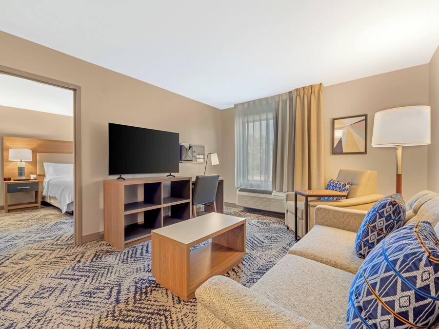 Une chambre d’hôtel équipée d’un canapé, d’une télévision, d’un bureau, d’une chaise et d’un lit.