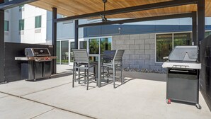 An outdoor patio with a grill, seating, and a ceiling fan. - Candlewood Suites Lawrenceville Princeton by IHG (Lawrenceville)