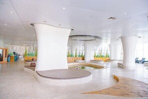 A spacious lobby with a central seating area, large pillars, and a water feature. - Links Resort (Rudong)