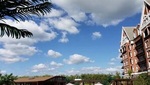 Un hotel de estilo arquitectónico tradicional, con varios balcones y un cielo despejado con nubes.
