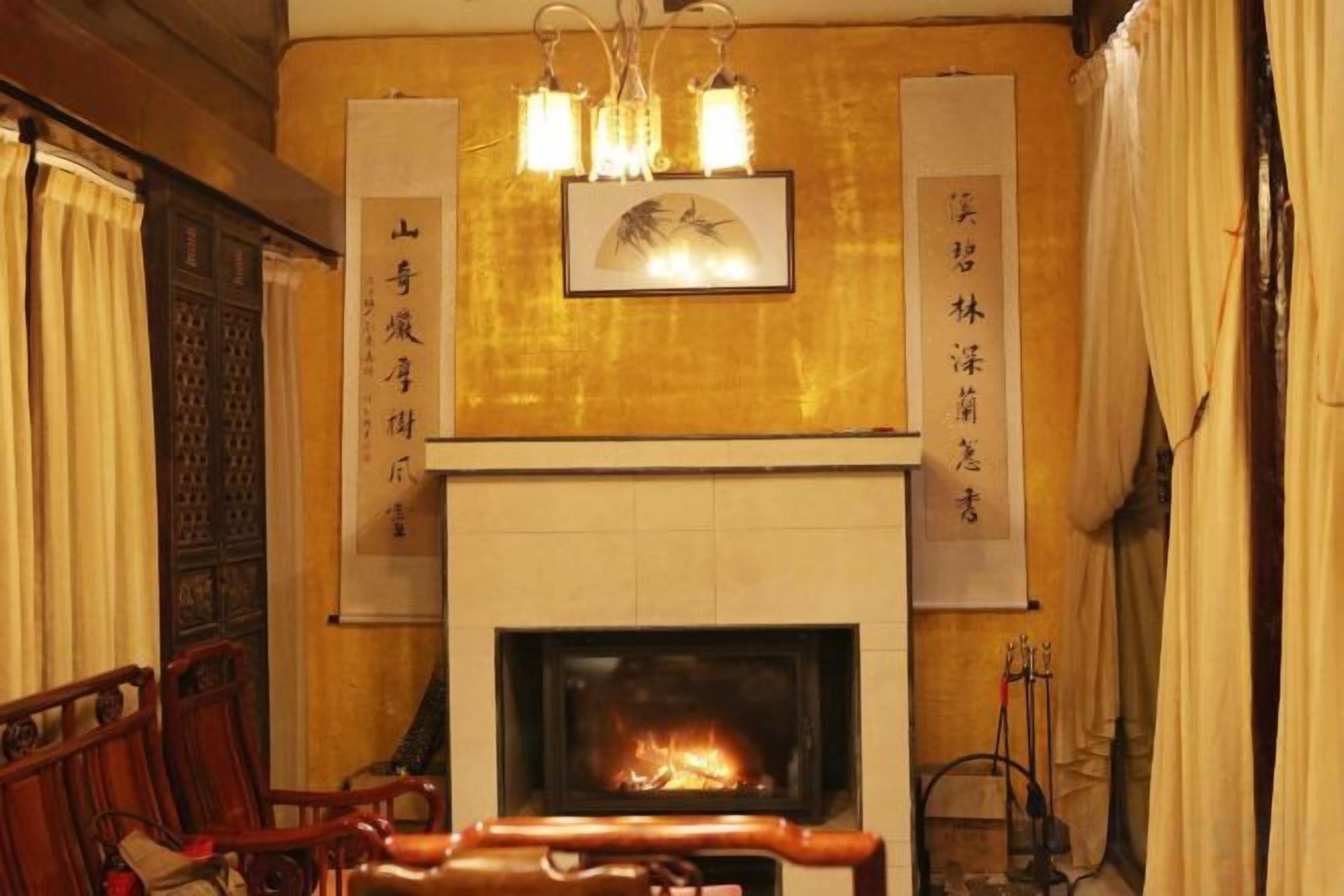 Un interior tradicional con chimenea, muebles de madera y caligrafía en las paredes.