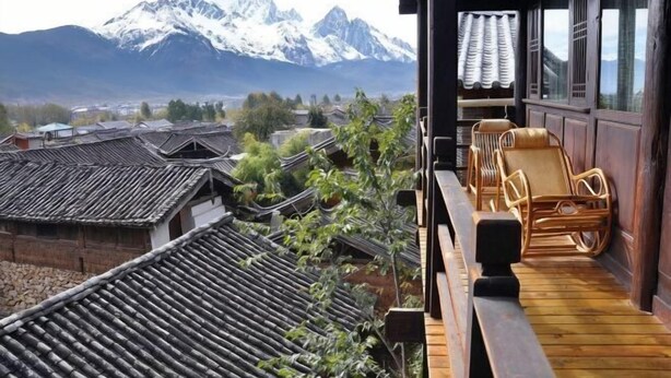 A traditional wooden building with a balcony overlooking a mountainous landscape. - Youtang Cloud Station CourtyardZen-style Inn (Lijiang Shuhe Ancient Town Branch) (Lijiang)