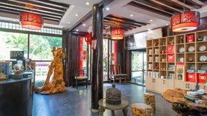 A spacious lobby with a reception desk, seating area, and a display of clocks and decorative items. - Youtang Cloud Station CourtyardZen-style Inn (Lijiang Shuhe Ancient Town Branch) (Lijiang)