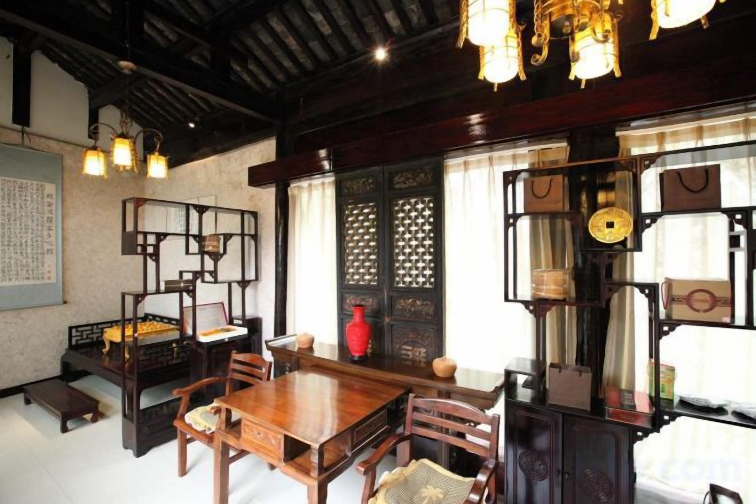 A traditional interior with a wooden dining table, chairs, and hanging light fixtures.