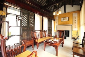 Una habitación tradicional con muebles de madera, chimenea y paneles decorativos.
