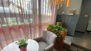 A modern room with a grey sofa, a round table, and potted plants. - Piaohome Chain Hotel (Beijing Guomao Dawang Road Subway Station Store) (Beijing)