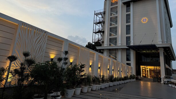 A modern hotel with a symmetrical facade, large windows, and a central entrance. - The Hotel Mudra (Varanasi)