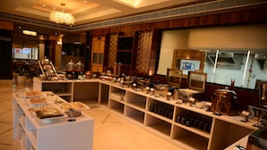 A buffet setup with various food items and beverages. - The Hotel Mudra (Varanasi)