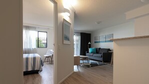 A modern living room with a sofa, a coffee table, and a dining area with a table and chairs. - Unit 46 - Resort Living, Luxury getaway, Close 2 Noosa River (Noosaville)