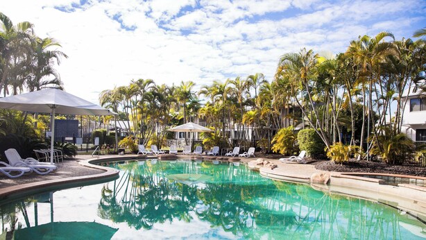 A swimming pool with lounge chairs and umbrellas, surrounded by palm trees. - Unit 46 - Resort Living, Luxury getaway, Close 2 Noosa River (Noosaville)