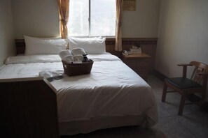 A hotel room with a bed, a chair, a nightstand, and a window with curtains. - Shexia Li Yu (Pingtung)
