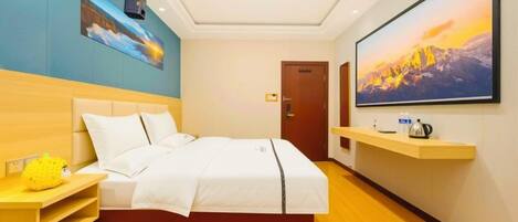 A hotel room with a bed, a TV mounted on the wall, a wooden nightstand, and a painting above the bed.