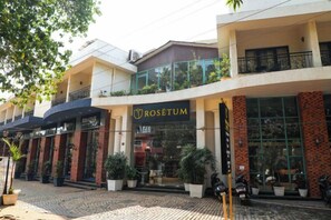A building with a storefront named 'Rosetum' and a balcony with potted plants. - Rosetum Anjuna Goa (Anjuna)