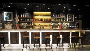 A bar area with a counter, multiple shelves of bottles, and several stools. - Rosetum Anjuna Goa (Anjuna)