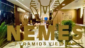 Un vestíbulo de hotel con un cartel grande que dice "NEMES Pyramids View".