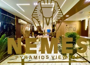 A hotel lobby with a large sign reading "NEMES Pyramids View". - Nemes Pyramids View Inn (Giza)