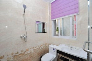 A bathroom with a toilet, sink, and shower.