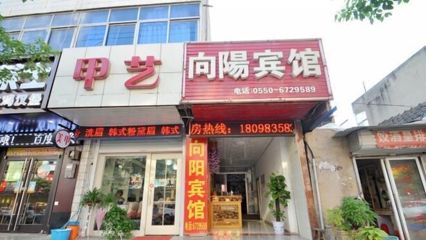 A building with a sign for '甲艺' and '向阳宾馆'. - Fengyang Xiangyang Hotel (Fengyang)