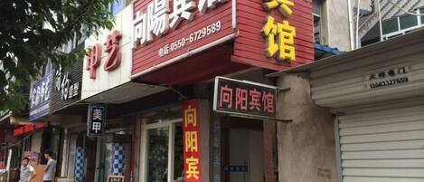 A row of storefronts with signage in Chinese, including one for a hotel named "向阳宾馆".