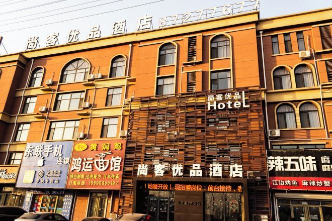 A hotel with a traditional facade, multiple windows, and signage for various businesses.