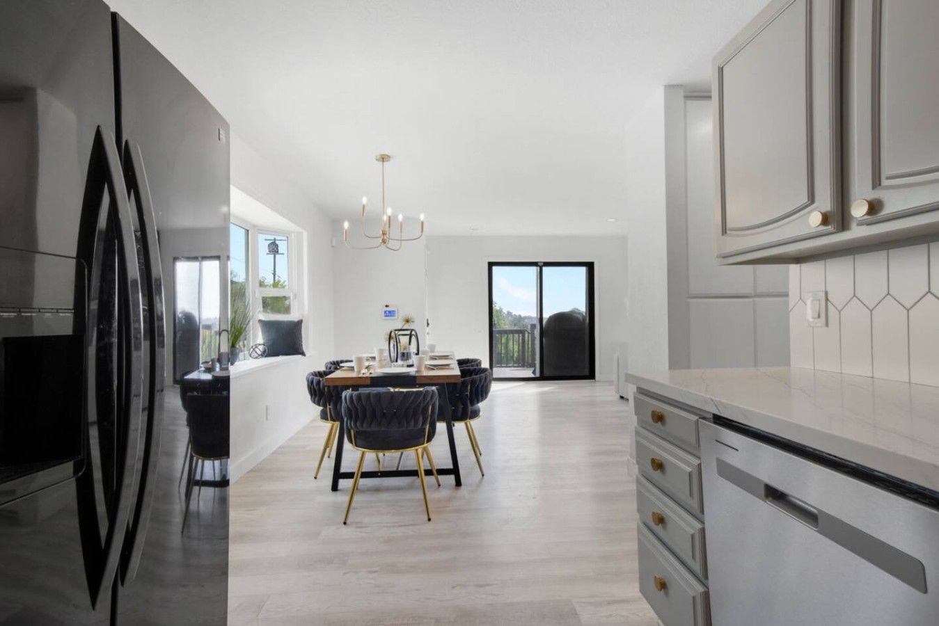 Una cocina moderna con comedor, ventanas amplias y vistas al exterior.